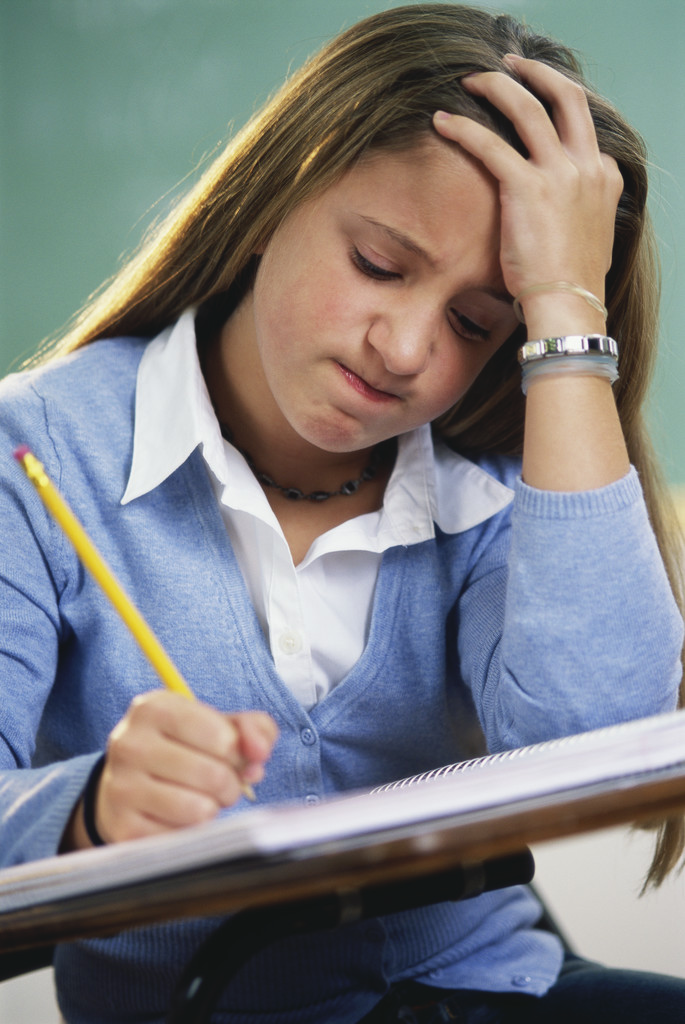 Photo of female student visibly struggling with classwork